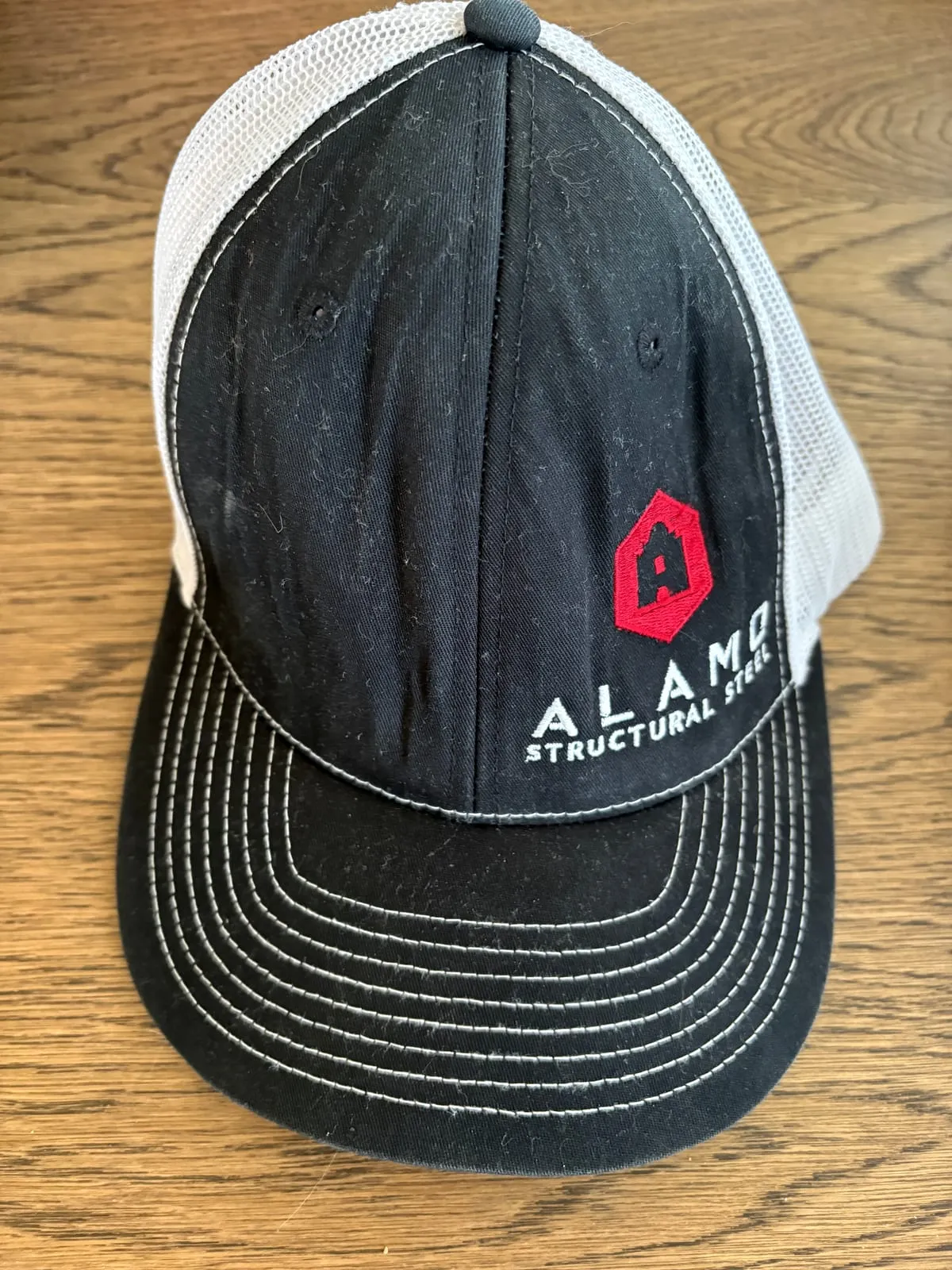 Retired black and white Alamo Structural Steel trucker hat