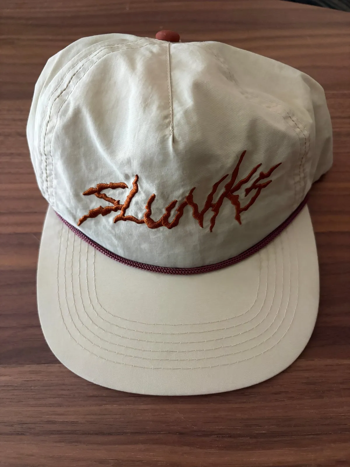 Retired tan Slunks rope cap with rust script lettering